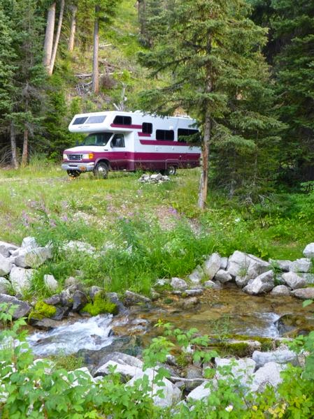 Motorhome in forest by stream