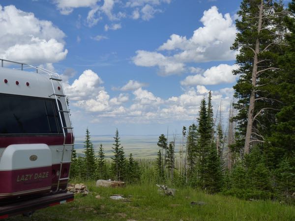RV, trees, valley, clouds